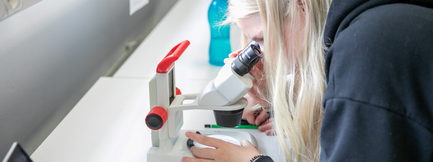 a student using a microscope