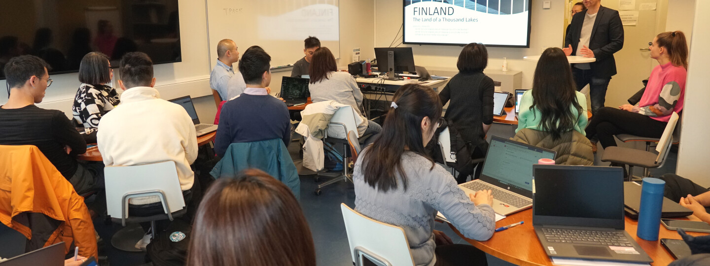 A group of people sitting in a room listening to a person talking