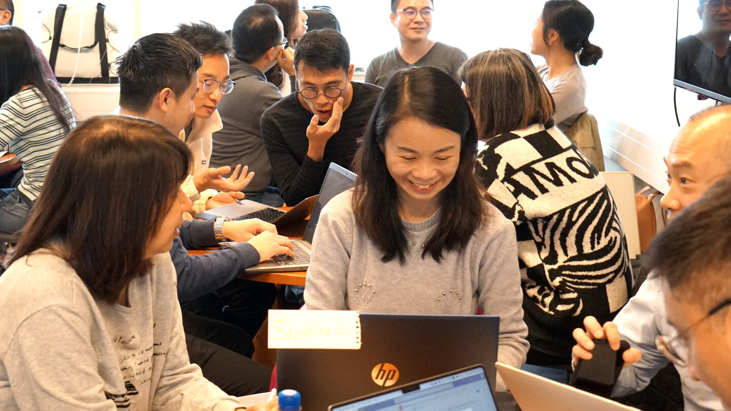 A group of visitors from Hong Kong sitting in a classroom