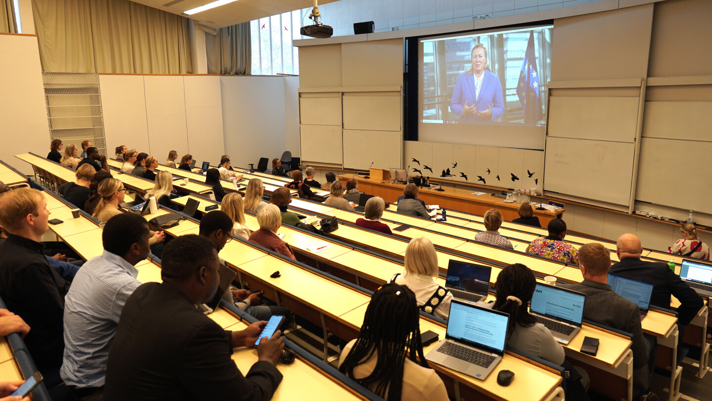 Audience watching to a video message from Commissioner Urpilainen