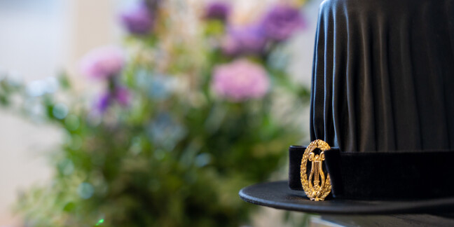 Doctoral hat with a bouquet of flowers in the background