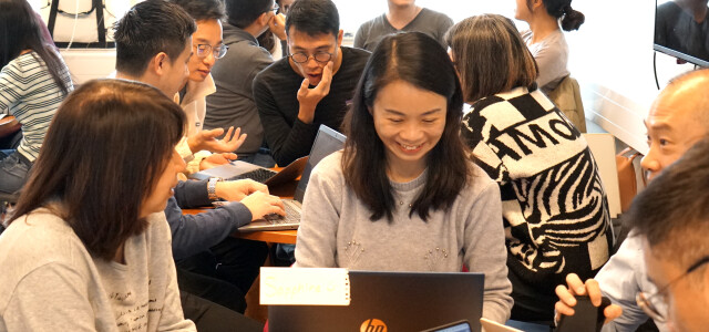 A group of visitors from Hong Kong sitting in a classroom