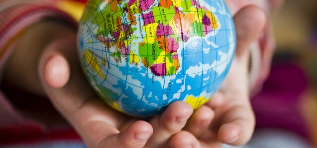 Young hands holding a globe ball