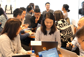 A group of visitors from Hong Kong sitting in a classroom