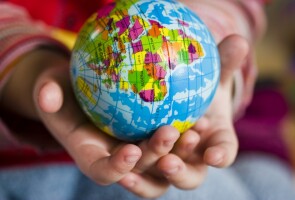 Young hands holding a globe ball